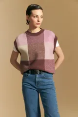 Chaleco tejido de punto con diseño de bloques a cuadros en tonos rosados, marrones y beige. Presenta cuello redondo y terminaciones acanaladas en cuello y sisas.
