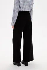 Pantalon de jean negro de corte ancho y tiro alto, con cierre frontal y bolsillos laterales.