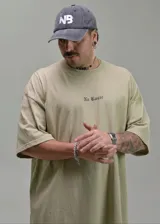 Remera oversize de color beige con estampa tipográfica pequeña en el pecho y diseño de manga corta.