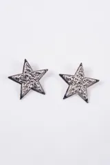 Aros con diseño de estrella calada con textura interna, en acabado plateado.