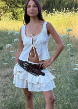 Falda corta de color crudo con diseño de volados escalonados. Incluye un short interno para mayor comodidad y está confeccionada en una tela liviana y fresca.