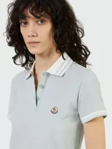 Remera polo celeste de algodón piqué, con cuello clásico y tapeta de dos botones. Tiene mangas cortas con ribete a tono y logo de la marca bordado en el pecho.