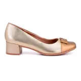 Zapato de cuero dorado con puntera color bronce y detalle de moño con apliques brillantes. Tiene taco bajo cuadrado.