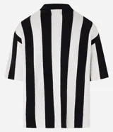 Sweater de punto con diseño de rayas verticales blancas y negras, cuello polo con escote en V y manga corta. Presenta un parche bordado en el pecho izquierdo con rosas y estrellas, y un estampado central con el texto "DISRUPT SPORTING CLUB".