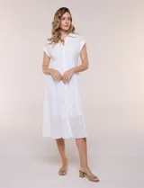 Vestido midi blanco estilo camisero de la marca Julia Jordan, confeccionado en tejido broderie 100% algodón. Presenta cuello camisero tradicional, cierre frontal con botones, mangas cortas con vuelta y cintura entallada con pinzas que da paso a una falda evasé. Cuenta con forro interior.