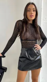 Body de red negro con mangas largas, cuello redondo y apliques de strass brillantes en toda la prenda. Presenta un diseño ajustado al cuerpo con una textura calada.