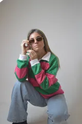 Sweater a rayas horizontales rosas y verdes, con cuello polo blanco y puños blancos.