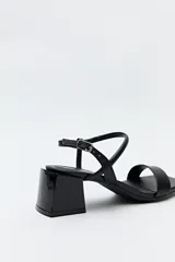 Sandalias rojas con tiras finas cruzadas y cierre con hebilla lateral. Su taco geométrico aporta un toque moderno y vanguardista.