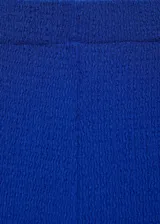 Pantalón de corte recto y tiro alto, confeccionado en tejido fluido con textura. Presenta cintura elástica para mayor comodidad.