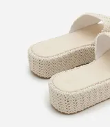 Sandalia tipo flatform con suela de plataforma plana y tira ancha superior, ambas con textura trenzada. Diseño sin cierre con puntera redonda.