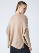 Suéter poncho de mujer, color gris claro, tejido en cashmere, con cuello en V, mangas largas acanaladas y aberturas laterales.