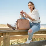 Botín de cuero vacuno color marrón oscuro, con taco de madera foliado en cuero de 5cm de altura, cierre lateral interno y horma de punta fina.