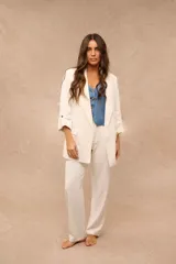 Blazer Jade de color blanco, corte oversize, con solapas clásicas, bolsillos con solapa en la parte frontal y mangas largas con presilla y botón para arremangarse.