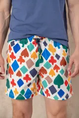 Short de baño para hombre, tiro medio, con elástico y cordón ajustable en la cintura. Presenta un estampado multicolor sobre fondo blanco con figuras geométricas que asemejan los palos de la baraja (corazones, picas, diamantes y tréboles).