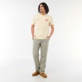 Remera de manga corta color beige, con cuello redondo y estampado frontal con la inscripción "Sunset Drive" y detalles tipográficos en el pecho.