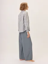 Pantalón ancho de algodón color verde oliva, con corte holgado desde la cadera hasta el tobillo. Presenta pinzas debajo de la rodilla, bordado de monograma en el bolsillo delantero y pespuntes a contratono.