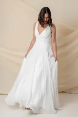 Vestido largo blanco de gasa, con corsé armado y falda con caída desde debajo del busto.