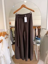 Pantalón palazzo de tiro alto color marrón, confeccionado en lyocell, con cintura elastizada, pinzas delanteras y lazo ajustable.