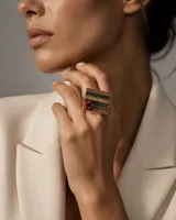 Anillo de diseño artesanal con base cuadrada de madera trabajada en técnica de taracea con vetas naturales, decorado con una pieza circular de coral rojo y engarzado en plata.