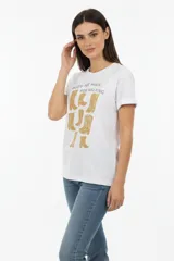 Remera de algodón negra con cuello redondo y mangas cortas. Presenta un estampado frontal con la frase 'WANTED AND WILD', gráficos de revólveres, estrellas y texto alusivo a un festival western.