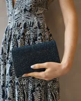 Clutch rectangular de fiesta en color azul noche, con acabado brillante y cristales engarzados en toda su superficie.