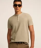 Polo de hombre de manga corta, color beige claro, con cuello mao y tapeta de dos botones.