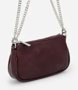 Cartera bandolera de formato compacto en cuero sintético color bordó, con cierre superior y doble correa de cadena metálica plateada.