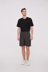 Bermuda de corte recto y diseño minimalista, confeccionada en tejido técnico de poliéster. Presenta cintura elástica con cierre de botón frontal, bolsillos laterales y un bolsillo pequeño adicional en el lateral izquierdo.