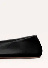 Zapato plano tipo chatita, de color negro, confeccionado en piel de ovino con diseño minimalista y puntera cuadrada.