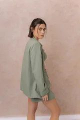 Blazer de lino color verde militar, con solapa clásica, calce recto, cierre frontal de un botón y mangas largas.