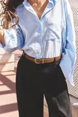 Pantalón verde oliva de lino con tiro alto, pinzas delanteras, bolsillos frontales y falsos bolsillos con solapa en la espalda. Incluye cinturón marrón y cierre delantero con cremallera, botón interior y gancho.