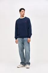 Buzo de cuello redondo en felpa con friza, color azul marino con detalle de cuello en color crema. Presenta bordado de la marca en el pecho y en el puño de la manga.