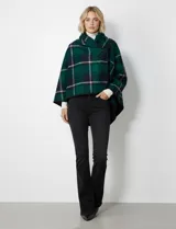 Capa de tejido cuadrille con diseño de cuadros en tonos marrón, beige y naranja. Presenta un cierre frontal con botón tipo trenca y bordes con ribete negro.