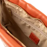 Bandolera naranja de cuero sintético con diseño acolchado rectangular y costuras a tono. Tiene acceso con cierre, correa regulable, herrajes dorados, un compartimento principal y bolsillos internos (uno con cierre y otro abierto).