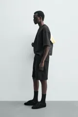Bermuda estilo jogger de ajuste relajado, color negro, confeccionada en tejido interlock de algodón. Cuenta con cintura elástica ajustable mediante cordón, bolsillos delanteros tipo vivo y diseño liso.