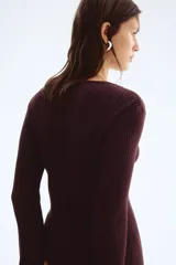 Cárdigan largo de punto acanalado color marrón oscuro, con escote en V y cierre frontal de botones de cúpula. Presenta remates acanalados de raya fina.