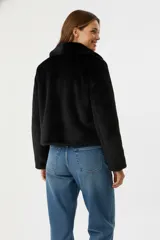 Chaqueta corta de piel sintética en color negro, con cuello clásico, cierre frontal con cremallera y mangas largas.