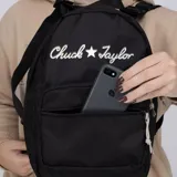 Mochila Converse modelo Go 2, color negro, con diseño funcional que incluye compartimento principal con cierre, bolsillo frontal con cierre y logo bordado de Chuck Taylor con estrella en la parte superior.