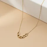 Collar de cadena fina en oro 9k con un detalle central de eslabones entrelazados.