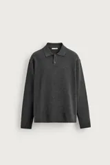 Polo de punto color negro, de corte regular fit, con cuello solapa, cierre frontal de dos botones y manga larga.
