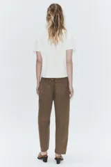 Jeans de tiro medio con corte cropped y diseño de costuras torcidas. Presenta trabillas en la cintura, cinco bolsillos clásicos y cierre frontal con cremallera y botón metálico.