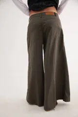 Pantalón de tiro medio con diseño de pierna ancha y cortes curvos que aportan movimiento. Presenta cintura ajustada, bolsillos delanteros y bolsillos plaque en la parte trasera.
