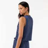 Top azul sin mangas de corte recto, con textura fruncida en todo su diseño, cuello redondo con sutil volado y terminación ondulada en el ruedo.
