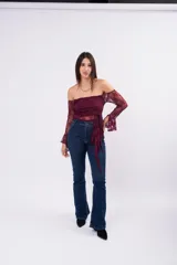 Blusa de encaje color bordó con diseño off-shoulder, mangas largas acampanadas y detalle de lazo frontal ajustable.