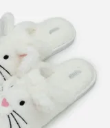 Pantufla tipo ojota confeccionada en tejido de peluche color blanco, con diseño de conejito que incluye orejitas, nariz bordada en rosa y bigotes negros. Posee suela de goma termoplástica.
