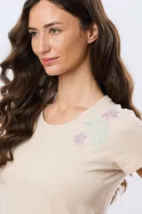 Remera blanca de manga corta y cuello redondo, confeccionada en algodón, con delicado bordado floral localizado en el hombro.