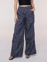 Pantalón wide leg de tiro medio con estampado animal print en tonos grises y negros, de corte holgado y bolsillos laterales. Cuenta con pretina elástica en la parte trasera y bolsillos delanteros aplicados.