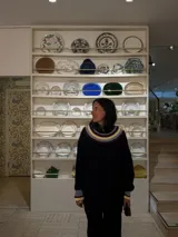 Buzo de punto negro de corte oversize, con cuello babero amplio decorado con franjas de colores y mangas largas con puños terminados en volados en contraste.