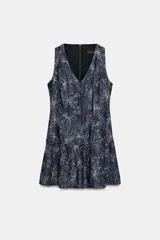 Vestido corto sin mangas de color azul marino, con escote en V y bordados florales a contraste. Presenta un diseño ajustado con corte en la cintura y falda con volante en el bajo. Cuenta con cierre de cremallera en la espalda.