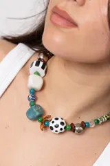 Collar corto de Lanka con abalorios variados, incluyendo cuentas esféricas con lunares, cubos blancos y negros, piezas de piedra turquesa, esferas de porcelana azul y blanca, y detalles metálicos plateados y marrones.